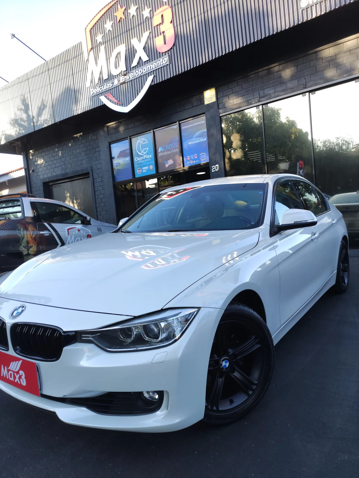 BMW branca em frente à fachada da Max 3 Películas em Toledo